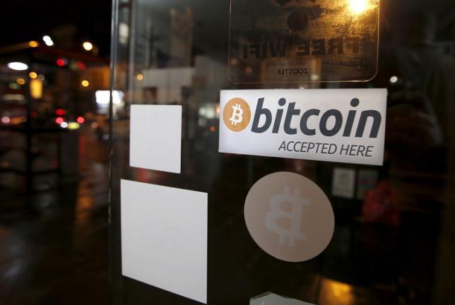 A bitcoin sticker is seen in the window of the 'Vape Lab' cafe, where it is possible to both use and purchase the bitcoin currency, in London